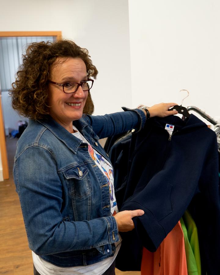 Mechthild Tüsfeld mit Textilien am Kleiderständer